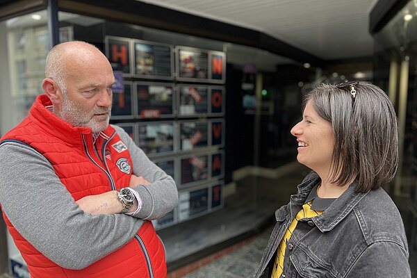 Sandra Jervis talking to a male resident in front of an estate agent office